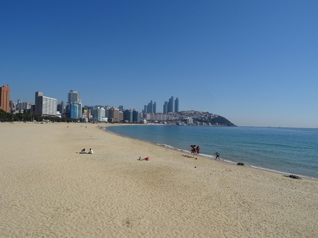 Haeundae Beach in Busan with sand, water, and the high-rise skyline along the shore