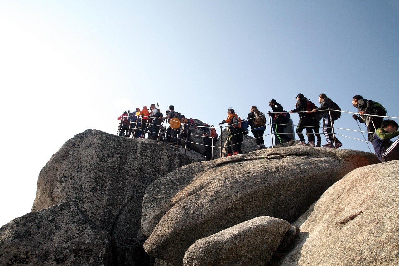 Hikers queuing along the rope-assisted rock section near Bukhansan's summit