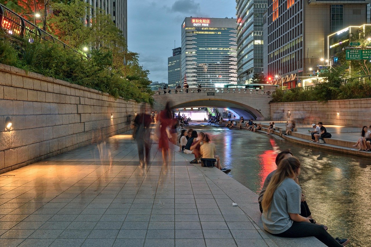 People sitting along Cheonggyecheon Stream in the evening in Seoul