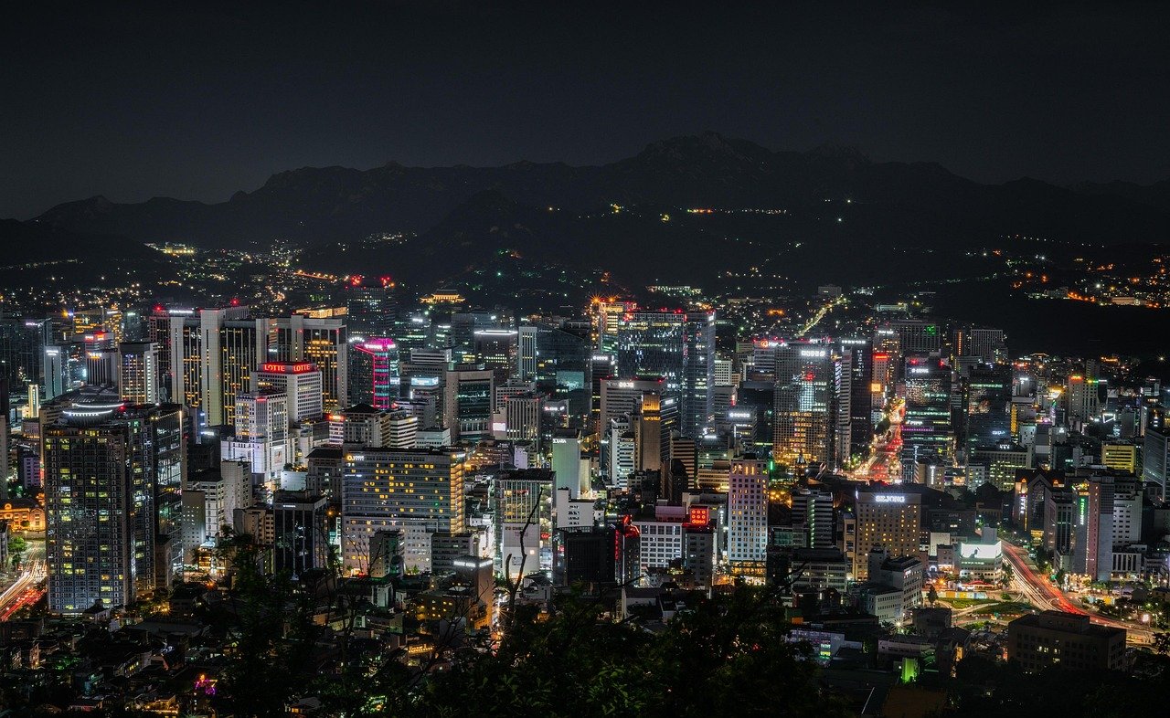 Seoul city skyline lit up at night with Namsan and Lotte tower in the background