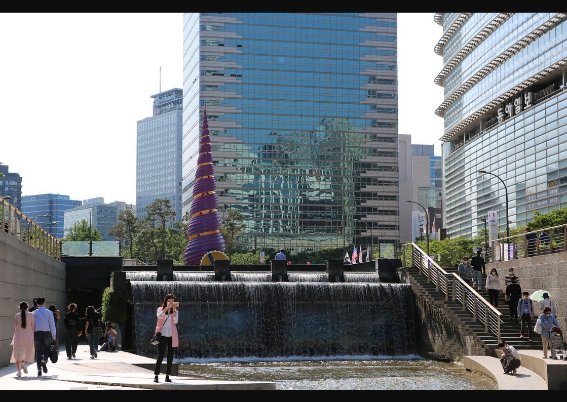 Daytime view of Cheonggyecheon Stream at Cheonggye Plaza, with the Spring sculpture and waterfall