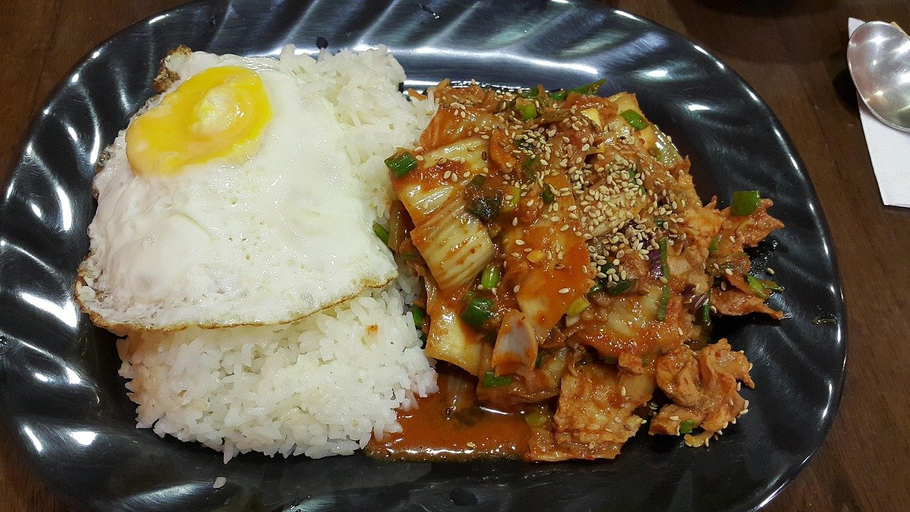 Korean home-style meal with rice, fried egg, and kimchi on a table