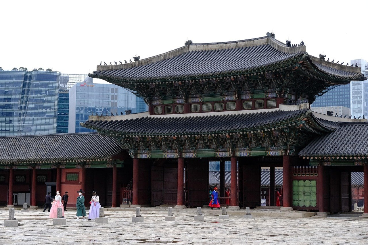 Gwanghwamun main gate of Gyeongbokgung Palace with visitors in hanbok