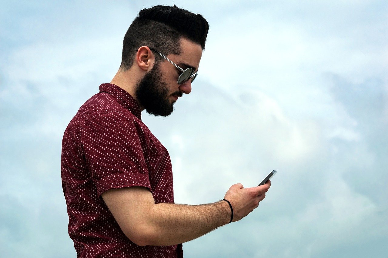 Person checking their smartphone after setting up a prepaid line at a telecom store