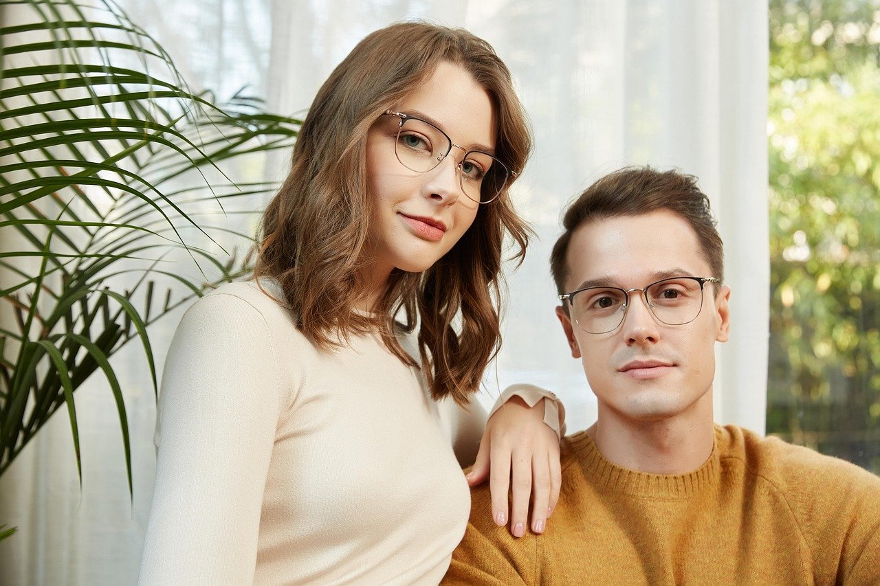 A young couple wearing glasses indoors