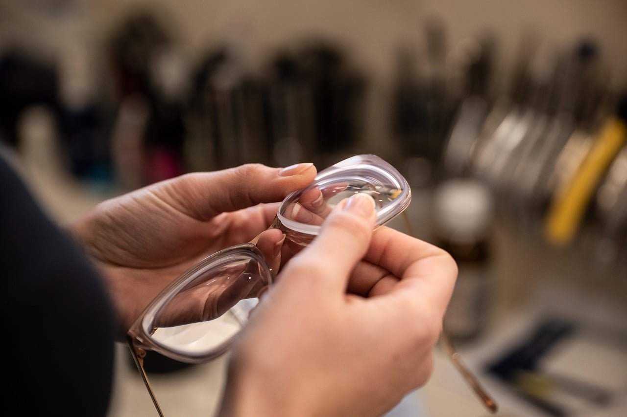 Optician's hands fitting and adjusting a pair of glasses frames