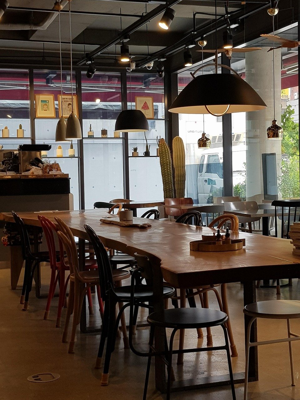 Industrial-style cafe interior with exposed track lighting and a large street-facing window in Seoul