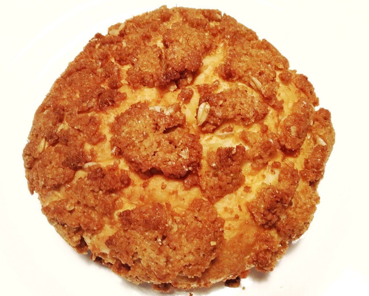 A plain baked soboro bun seen from above, its dry crumb topping cracked across the surface