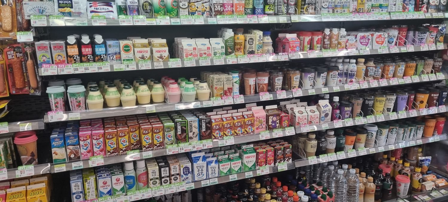 Coffee, milk and juice on the drinks shelves of a Korean convenience store with won price tags