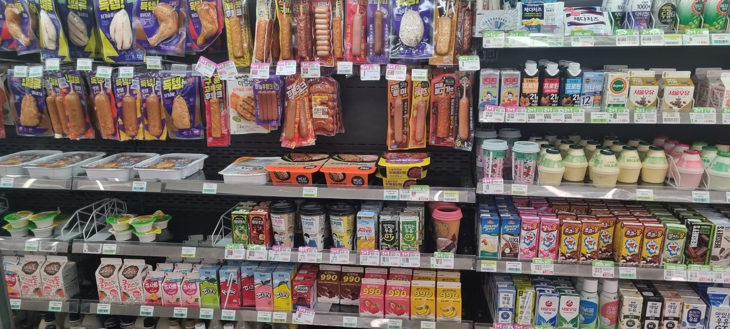 Sausages, ready meals and flavoured milk on the chilled shelves of a Korean convenience store