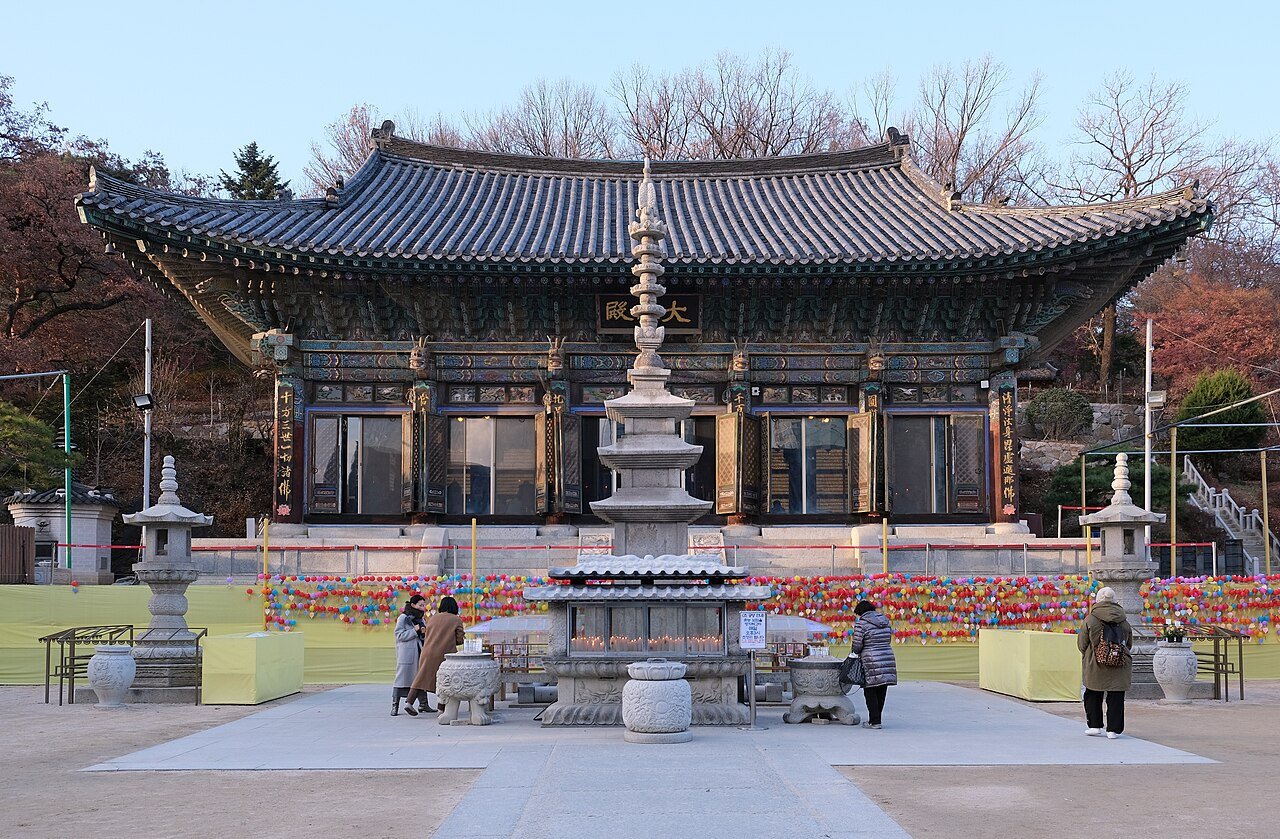Daeungjeon, the main hall at Bongeunsa, with a stone pagoda, candles and visitors in front of it