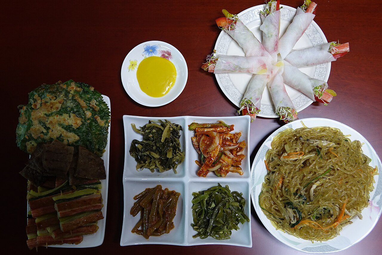 A Korean restaurant table set with a main dish and several banchan side dishes