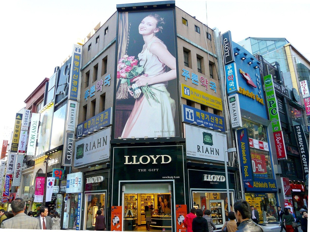 Storefront signs stacked up a building on a Korean shopping street