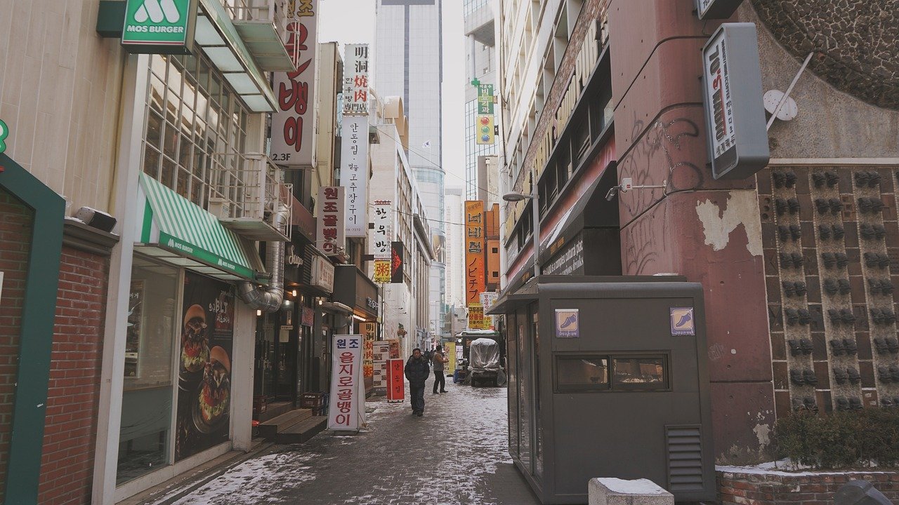 A narrow side street in Euljiro, Seoul, lined with Korean restaurant signs on a snowy winter day