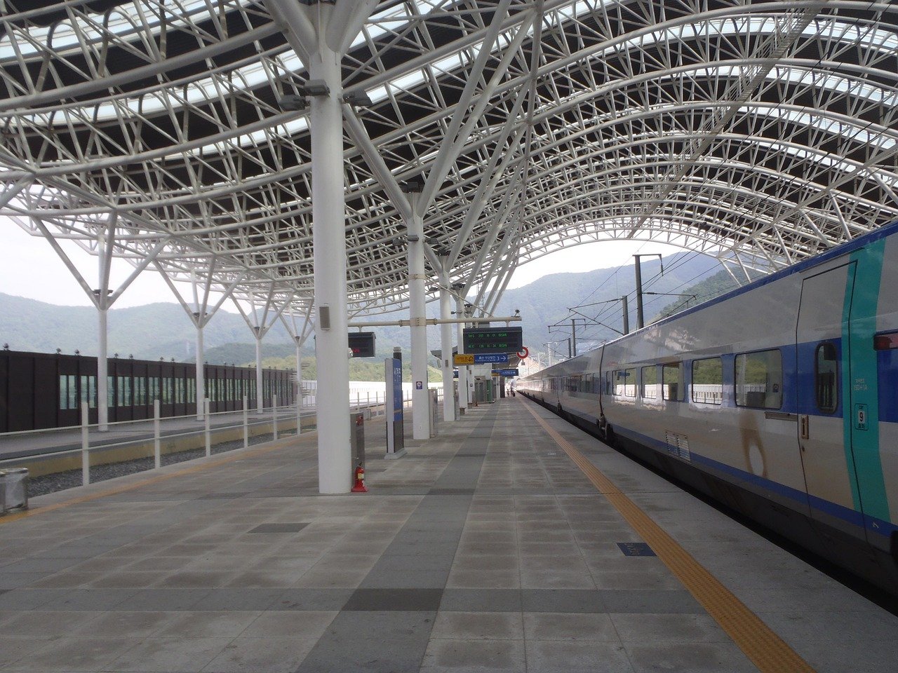 An empty KTX platform at a smaller Korean station with a train waiting at the edge